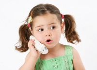 Toddler talking on a cordless phone.